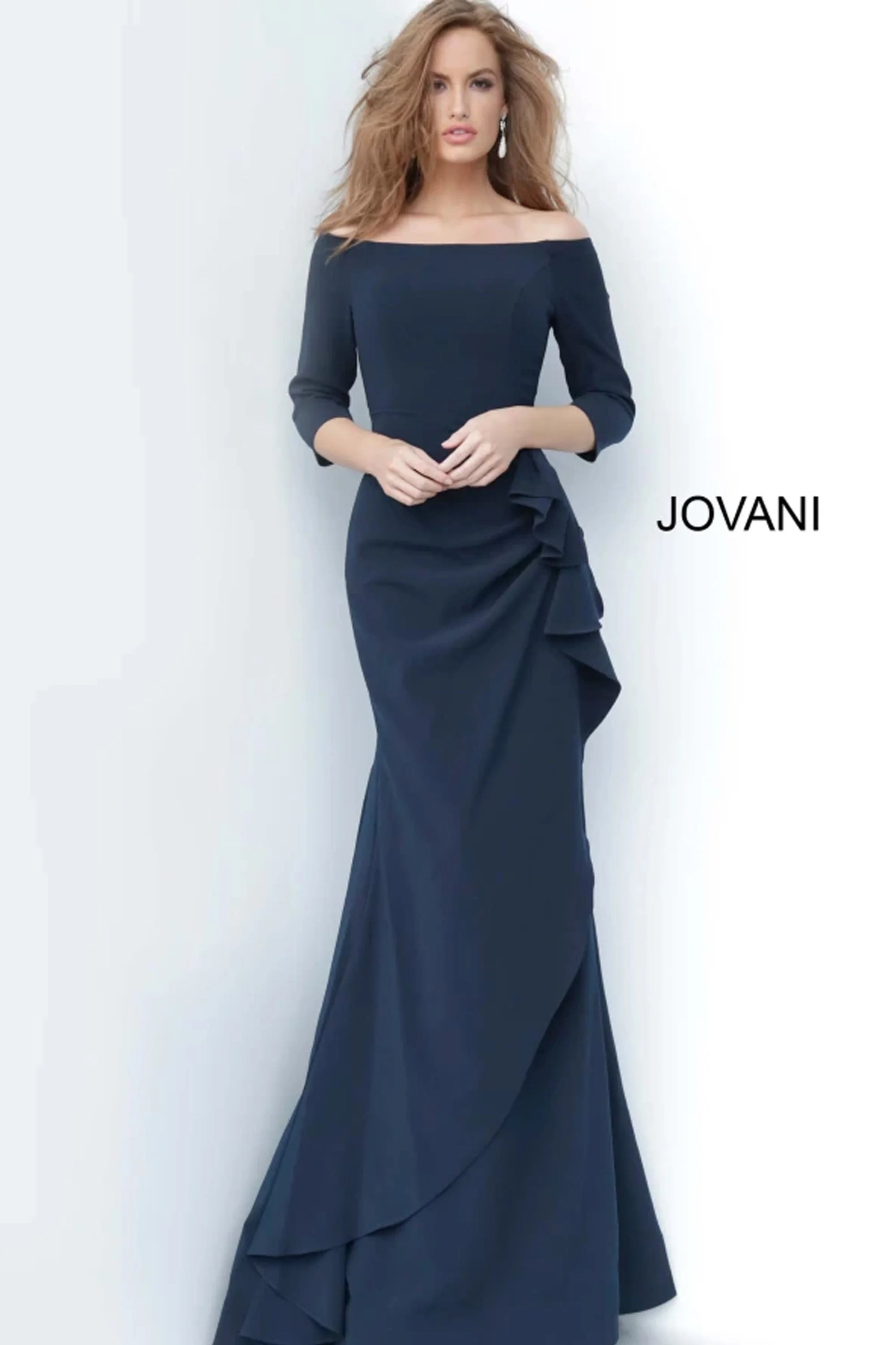 A model showcases a stunning navy gown with off-the-shoulder sleeves and a flowing skirt featuring elegant ruffles.