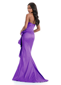 A model showcases a stunning strapless purple gown with a corset-style bodice and a flowing, ruched skirt. Perfect for elegant events like proms, galas, or black-tie weddings, this dress is conveniently available near Apex, Cary & Raleigh.