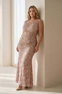 A model poses in a stunning sleeveless lace gown featuring a champagne ombre design, perfect for special occasions like mother of the bride, prom, or gala events. This elegant dress is conveniently located near Apex, Cary, and Raleigh.