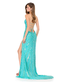A model showcases a stunning turquoise gown with intricate beading and a fitted silhouette, featuring a daring thigh-high slit and an elegant lace-up back.
