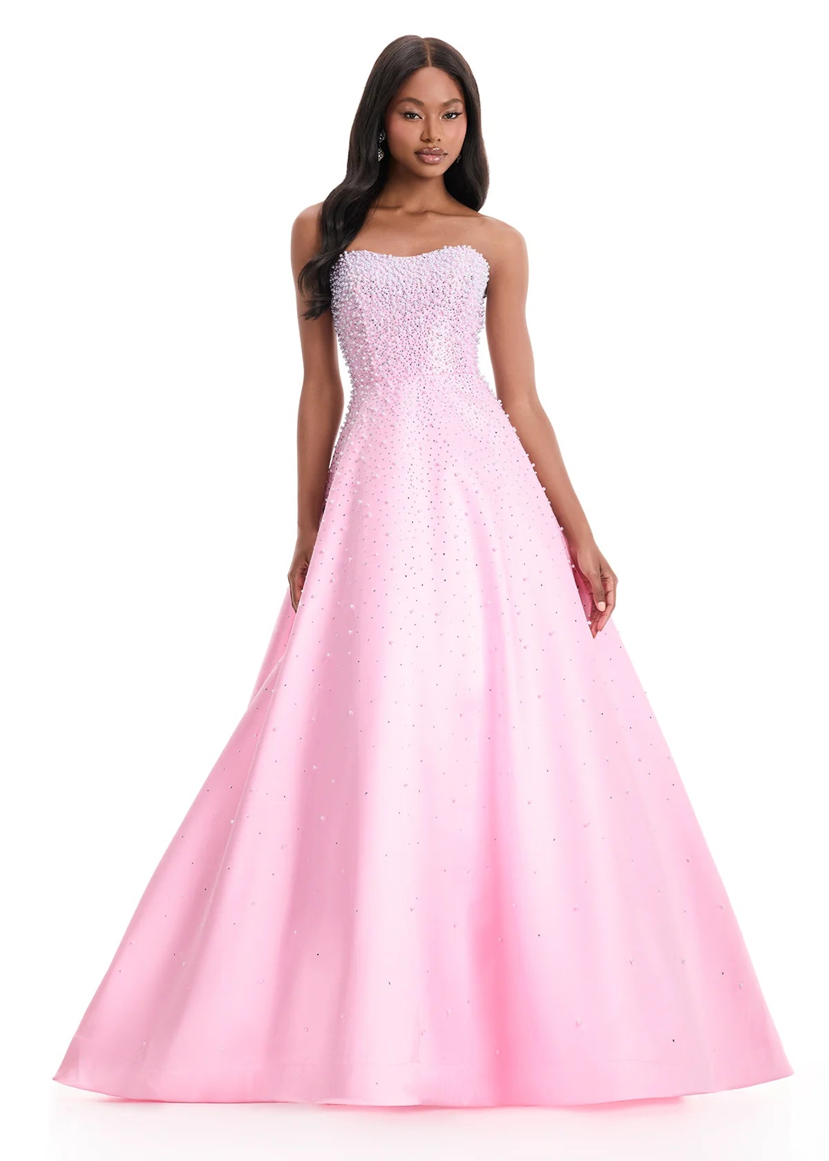 A model showcases a stunning strapless A-line gown in ice pink, embellished with crystal and pearl details. Perfect for special occasions like prom, galas, or black tie weddings, this gown is available near Apex, Cary, and Raleigh.