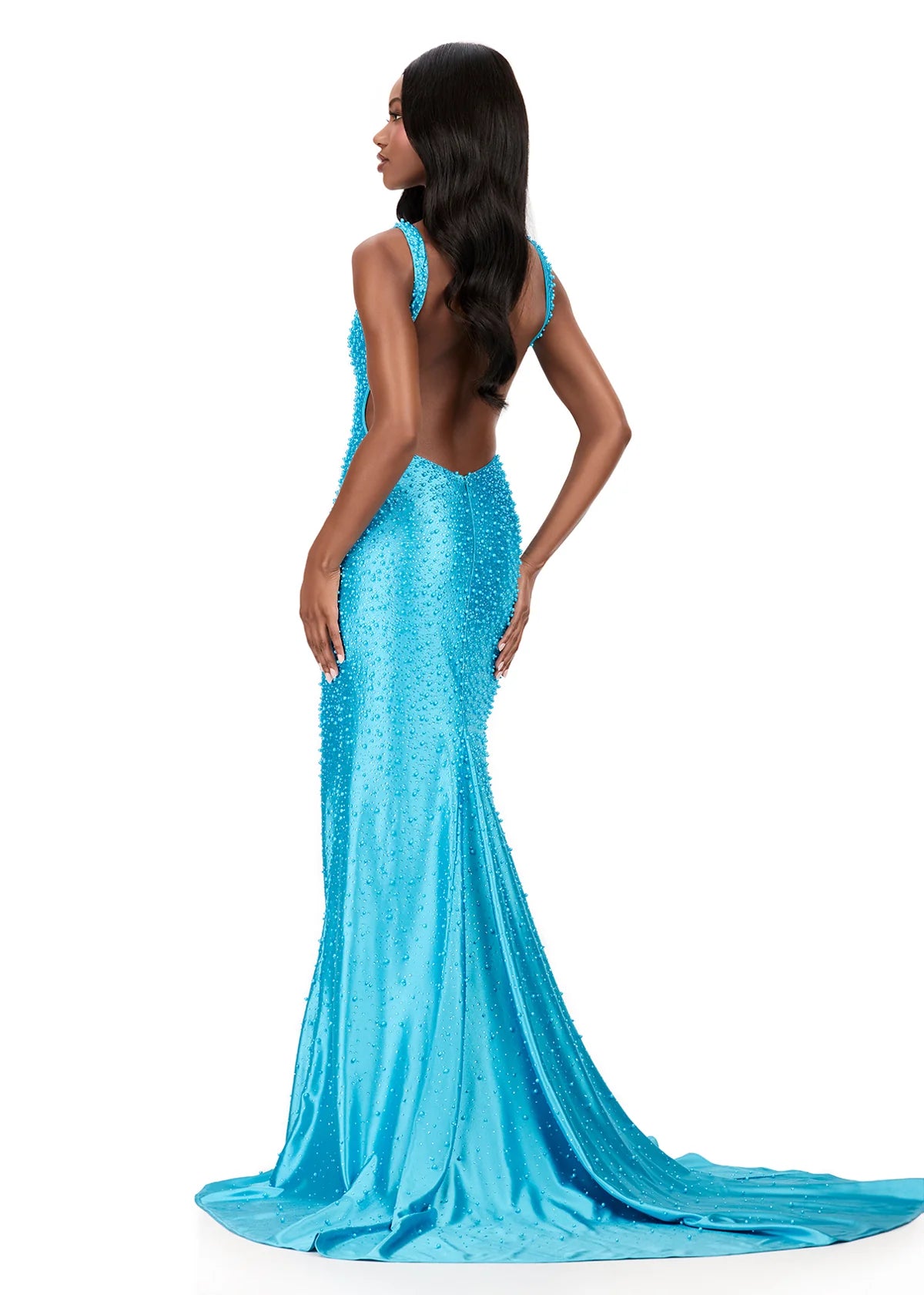 A model showcases a stunning turquoise beaded evening gown with a dramatic back design, perfect for formal events like galas or black tie weddings. This exquisite dress is conveniently available near Apex, Cary, and Raleigh.