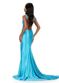 A model showcases a stunning turquoise beaded evening gown with a dramatic back design, perfect for formal events like galas or black tie weddings. This exquisite dress is conveniently available near Apex, Cary, and Raleigh.