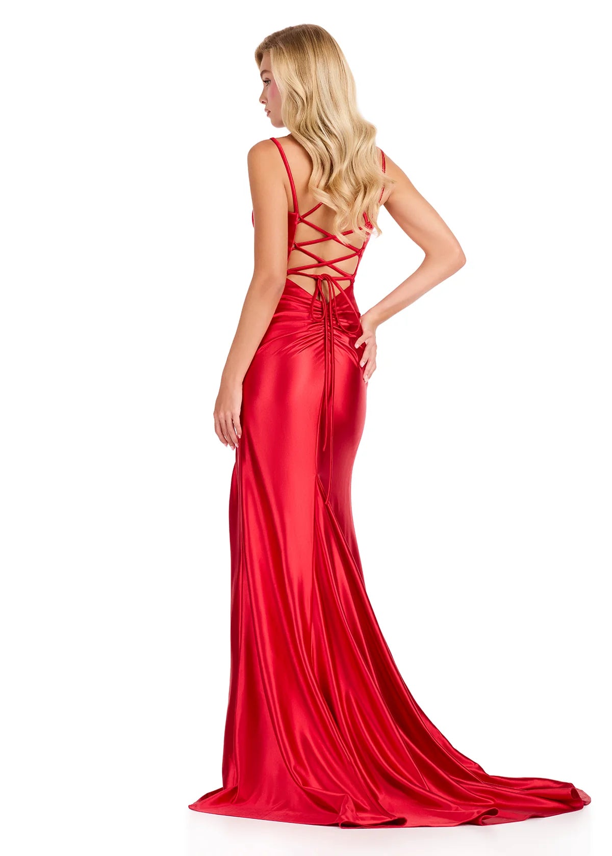 A model showcases a stunning red fitted jersey gown with a crisscross back design and a flowing train. This elegant dress is perfect for special occasions like prom, galas, or black tie weddings, available near Apex, Cary, and Raleigh.