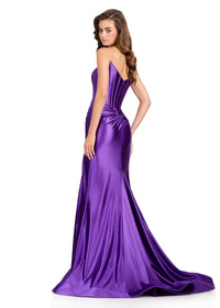 A model showcases a stunning purple strapless gown with a structured corset bodice and elegant train, ideal for formal events such as proms, galas, or weddings. Conveniently available near Apex, Cary, and Raleigh for your special occasion.