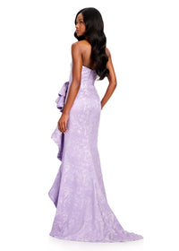 A model showcases an elegant lilac strapless gown with a structured bodice and flowing train. Perfect for special occasions like galas or weddings, this stunning dress is conveniently located near Apex, Cary, and Raleigh.