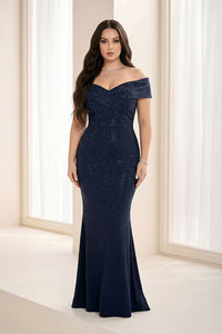 A model poses elegantly in a stunning navy off-the-shoulder gown adorned with sparkling embellishments.
