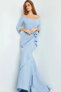 A model poses in an elegant light blue off-the-shoulder mermaid gown with ruffled detailing, perfect for special occasions like galas or weddings. This sophisticated dress is available near Apex, Cary, and Raleigh for easy access.