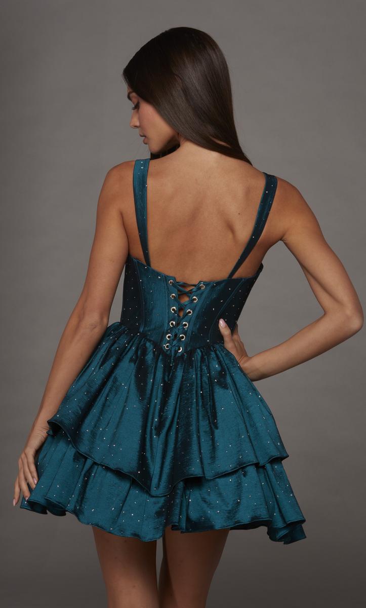 A model showcases a teal, tiered dress with a fitted bodice and lace-up back detail, ideal for events like prom or homecoming. This stylish dress is conveniently available near Apex, Cary, and Raleigh for easy access.