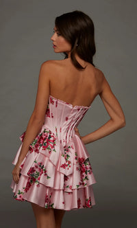 A young woman is shown from the back in a strapless pink dress adorned with floral patterns and layered ruffles.
