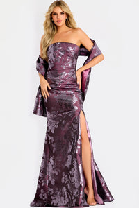 A model poses in a stunning burgundy strapless gown with a floral pattern and a thigh-high slit, complemented by a flowing shawl.