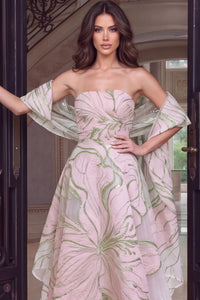 A model showcases a stunning strapless gown featuring intricate pink floral patterns and a flowing sheer overlay, perfect for elegant events like galas or black tie weddings.