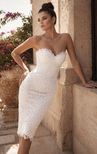 A model poses elegantly in a fitted off-white lace dress with a sweetheart neckline, showcasing delicate lace details and a flattering silhouette.