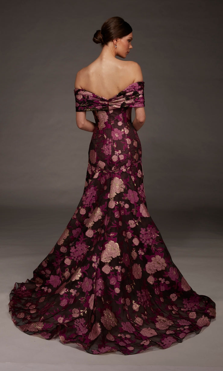 A model showcases an elegant off-the-shoulder gown featuring a floral pattern in deep burgundy and gold hues.