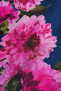 A close-up view of vibrant pink peony flowers against a deep blue background, showcasing rich colors and intricate details. This floral design is perfect for a formal event or a summer gathering, adding a touch of elegance to any occasion.