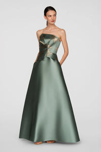 A model showcases a stunning soft sage ball gown with a metallic jacquard bodice and gold floral details.