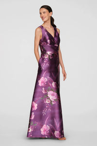 A model showcases a stunning floor-length gown adorned with a vibrant rose bouquet print in shades of purple and pink.