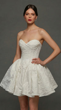 A model showcases a stunning white strapless dress with a fitted bodice and a flared skirt, featuring textured fabric.