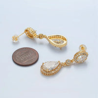 A pair of elegant gold drop earrings featuring a geometric design with micro-pave cubic zirconia accents, displayed next to a U.S. penny for size reference.