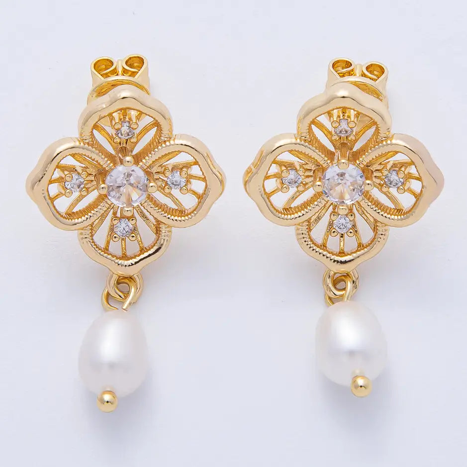 Elegant gold flower filigree earrings feature a central gemstone surrounded by delicate detailing and a pearl drop, perfect for adding a touch of sophistication to special occasions like weddings or galas.
