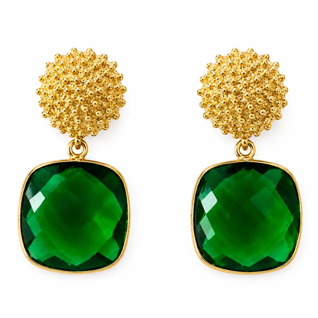 A pair of elegant gold earrings featuring a textured round stud and a large, faceted emerald-green stone.