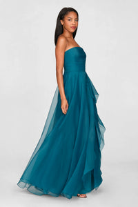 A model poses in a stunning teal strapless gown with draped layers, perfect for formal occasions like prom, galas, or weddings. This elegant dress is conveniently available near Apex, Cary, and Raleigh.