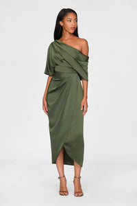 A model poses in a sleek, one-shoulder olive green gown featuring elegant draping and a thigh-high slit.