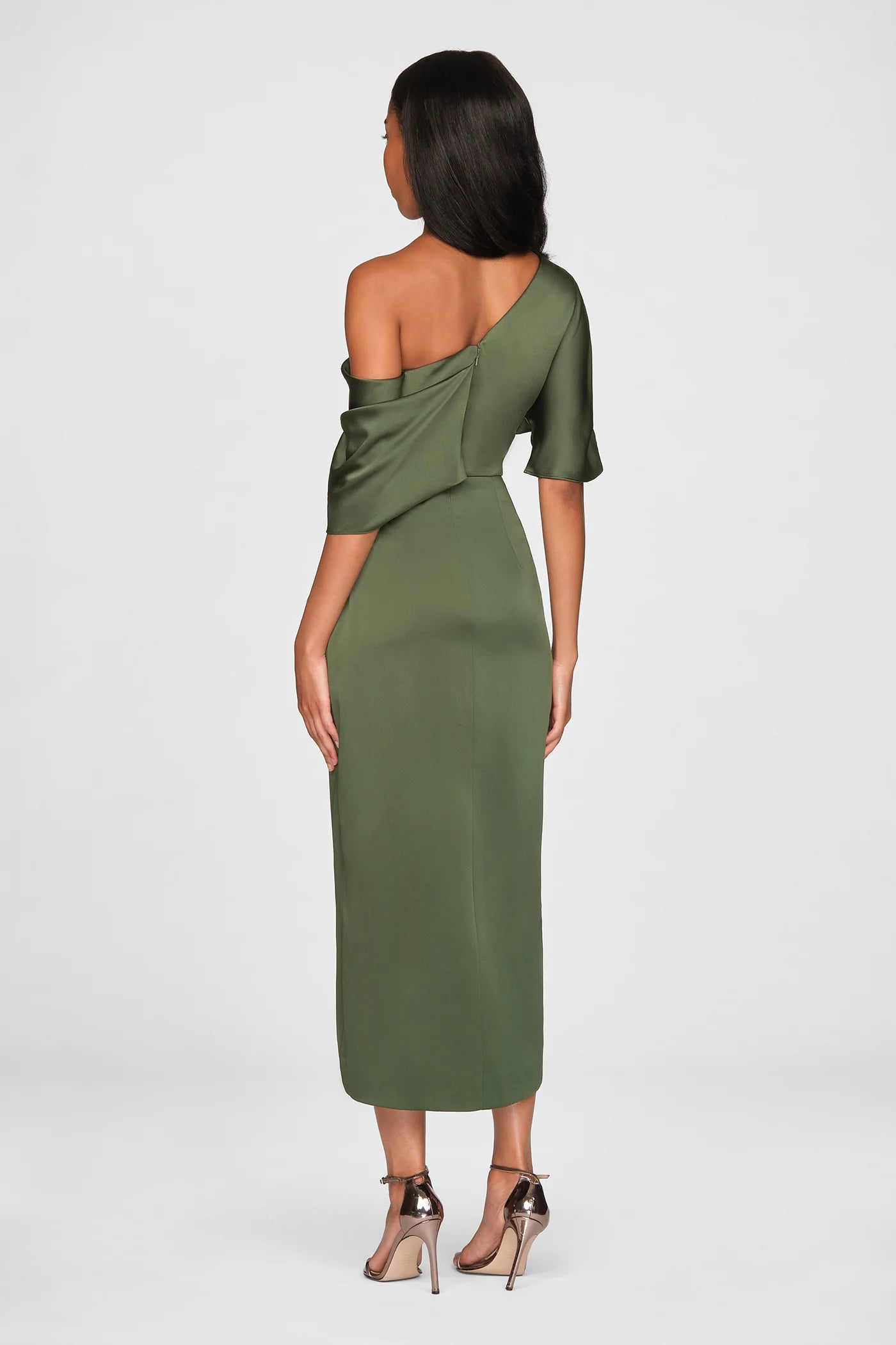 A model showcases a stylish olive green one-shoulder draped gown, featuring elegant satin fabric and a fitted silhouette.