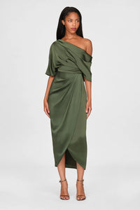 A model showcases a stunning olive green one-shoulder draped gown, featuring elegant satin fabric and a sleek silhouette. Perfect for a black tie wedding or gala, this dress is conveniently available near Apex, Cary, and Raleigh.