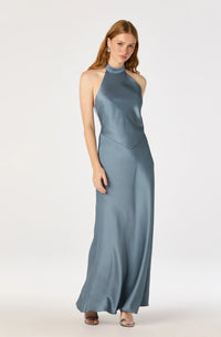 A model showcases a sleek satin maxi dress in a soft blue hue, featuring a high halter neckline and an elegant open back with a self-tie bow.
