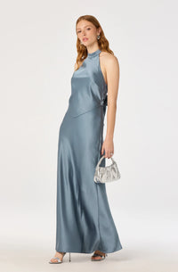 A model showcases a sleek satin maxi dress in a soft blue hue, featuring a high halter neckline and an elegant open back.