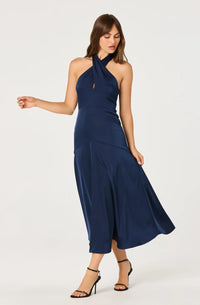 A model showcases a sleek navy satin dress featuring a halter neckline and a keyhole cutout. This elegant gown is perfect for special occasions like prom or galas, and is conveniently available near Apex, Cary, and Raleigh.