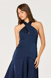 A model showcases a navy blue satin gown with a halter neckline and a keyhole detail, featuring a fitted bodice that flows into a flared skirt.