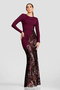 A model showcases a stunning burgundy gown featuring long sleeves and intricate sequin detailing on the skirt.