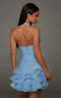A model showcases a light blue, tiered cocktail dress with a halter neck and a fitted bodice, perfect for special occasions like prom or homecoming.