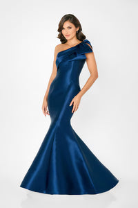 A model showcases a stunning one-shoulder mermaid gown in a rich sapphire blue, featuring a ruffled shoulder detail.