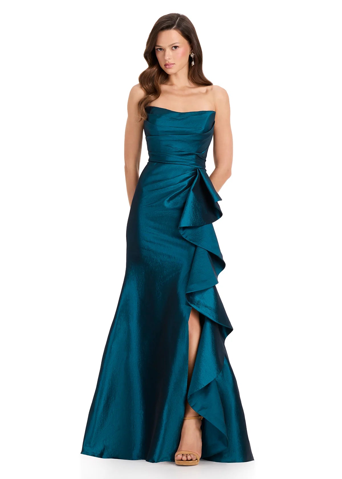 A model showcases a stunning dark teal strapless gown with a ruffled side detail and a thigh-high slit.