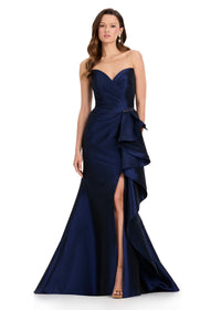 A model showcases a stunning strapless navy gown featuring a sweetheart neckline and elegant draping, perfect for events like proms, galas, or black tie weddings. This dress is conveniently available near Apex, Cary, and Raleigh.