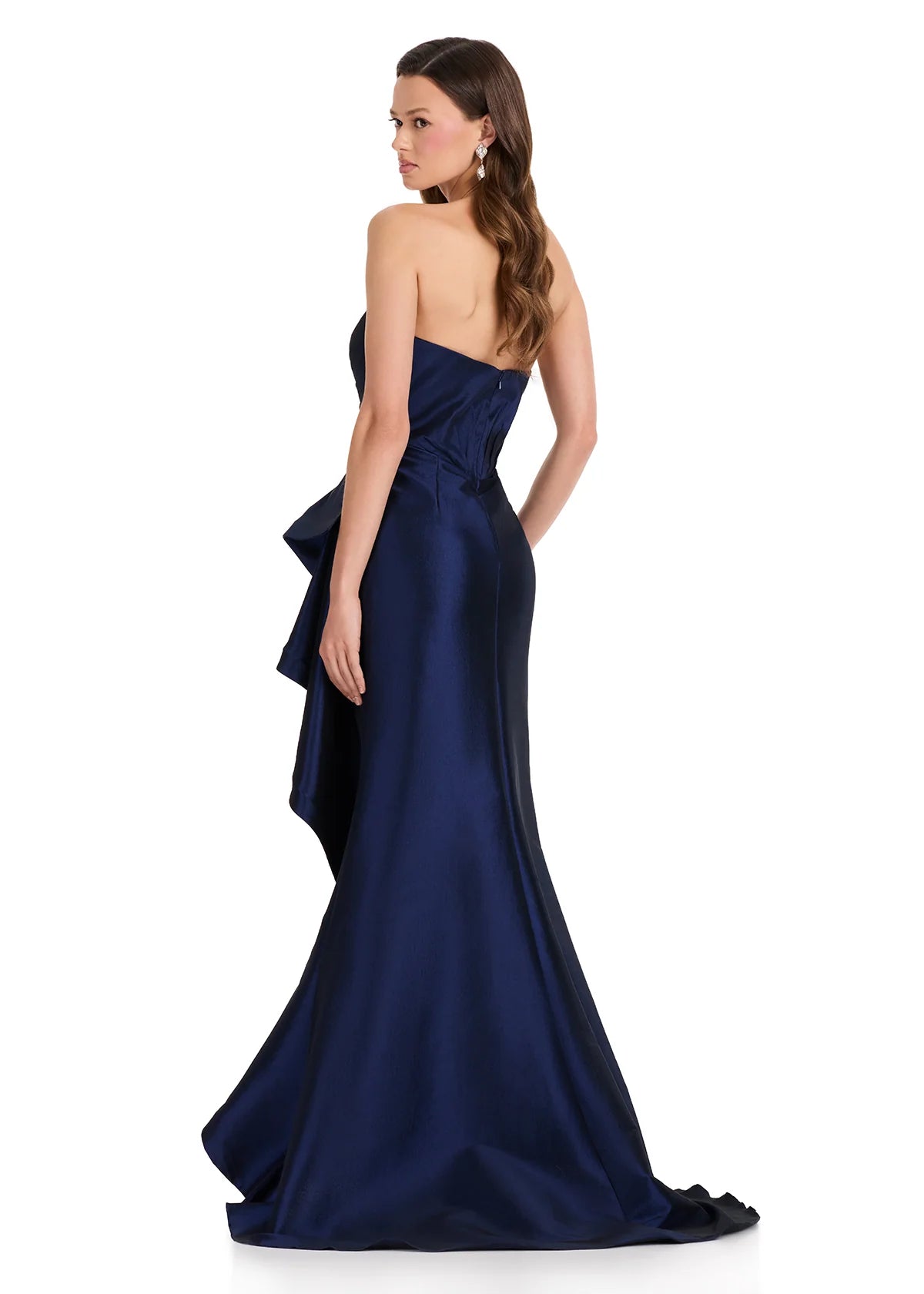 A woman models a stunning strapless navy gown featuring elegant draping and a structured silhouette. Ideal for special occasions like prom, gala events, or black tie weddings, these dresses are conveniently located near Apex, Cary,.