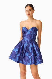 A model showcases a strapless mini dress in a vibrant cobalt blue with floral detailing, featuring a sweetheart neckline and a fit-and-flare silhouette.