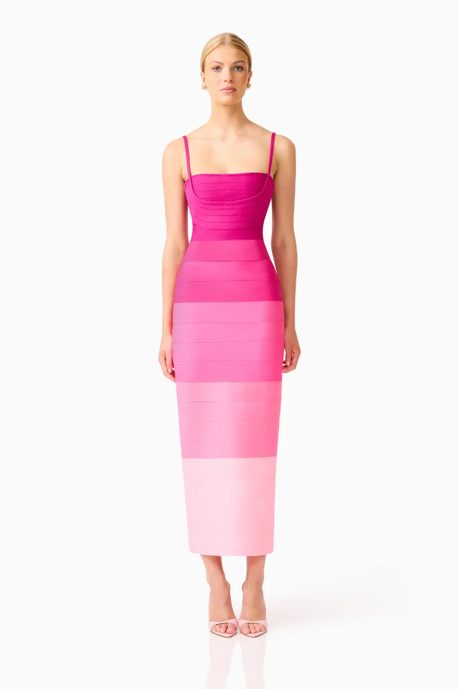 A model stands in a pink ombre gown featuring a square neckline and fitted silhouette, showcasing a gradient from deep pink to light pink.