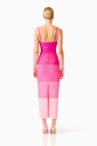 A model is seen from the back wearing a pink ombre gown featuring a square neckline and slim straps. This elegant dress, perfect for a gala or black tie wedding, is available near Apex, Cary, and Raleigh.
