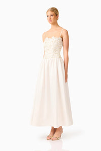 A model showcases a stunning ivory gown featuring delicate floral detailing on the bodice and a flowy skirt, perfect for bridal events, proms, or formal occasions. This elegant dress is conveniently located near Apex, Cary, and Raleigh.