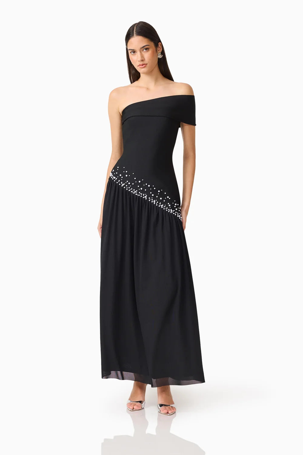 A model showcases a sleek black off-shoulder gown adorned with delicate embellishments along the waistline, perfect for elegant occasions like galas or black tie weddings.