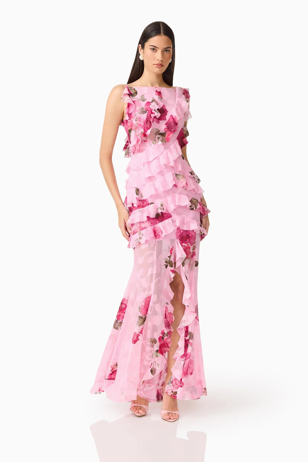 A model showcases a stunning sleeveless pink floral gown featuring ruffles and a thigh-high slit. This elegant dress is perfect for occasions like mother of the bride, prom, or garden parties, and is conveniently available near Apex,.