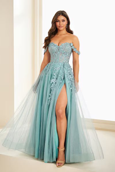 A model showcases a stunning off-the-shoulder gown in a soft sage color, featuring intricate three-dimensional floral lace detailing and a dramatic front slit.