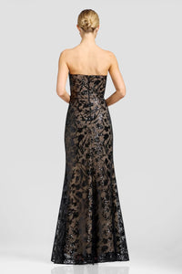 A woman is seen from the back, wearing a stunning strapless black gown adorned with floral metallic patterns and sequins.