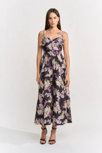A model stands confidently in a floral midi dress featuring a sweetheart neckline and delicate straps.