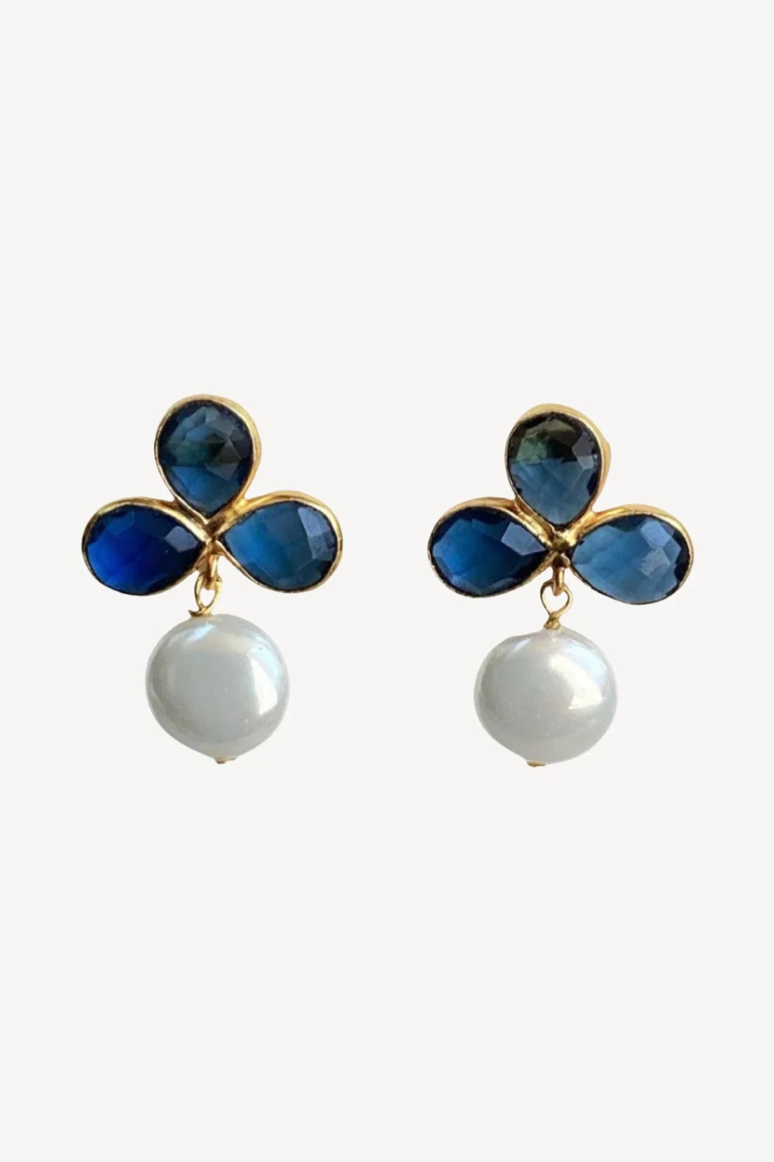 Elegant London Blue Sapphire earrings featuring a floral design with four blue gemstones and a lustrous freshwater pearl drop.