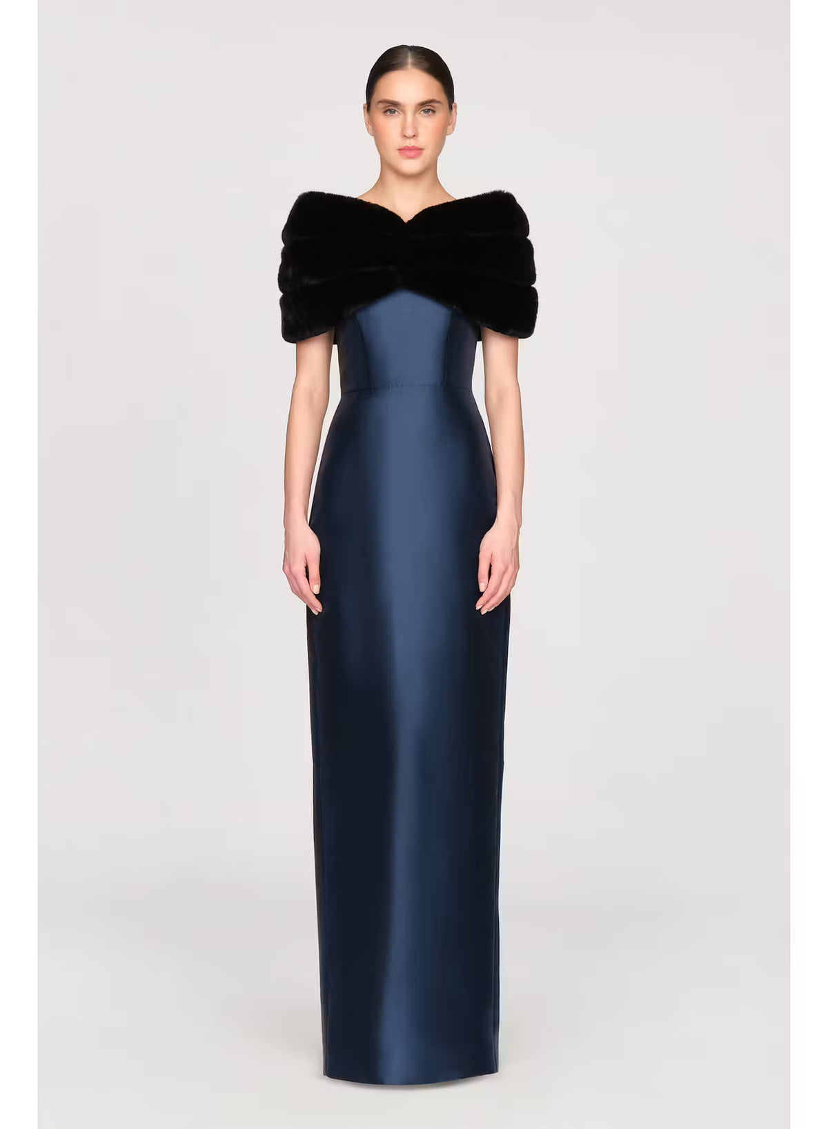 A model poses in a sleek, navy blue gown with a luxurious black faux mink shawl draped over the shoulders, perfect for elegant occasions like a black-tie wedding or gala.